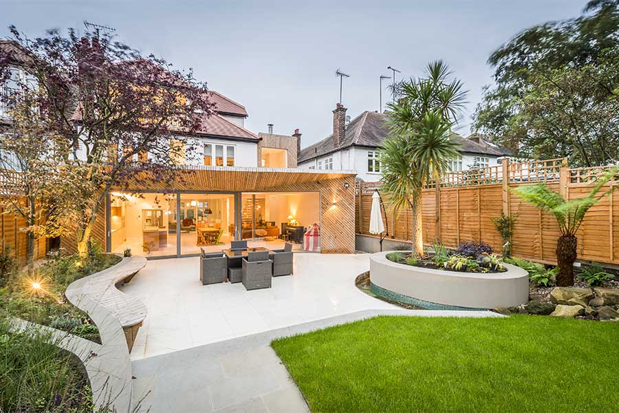 Lovely landscaped rear garden with large patio and low machinate but colourful planting