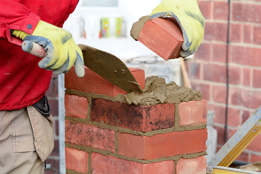 Building a wall with red engineering bricks