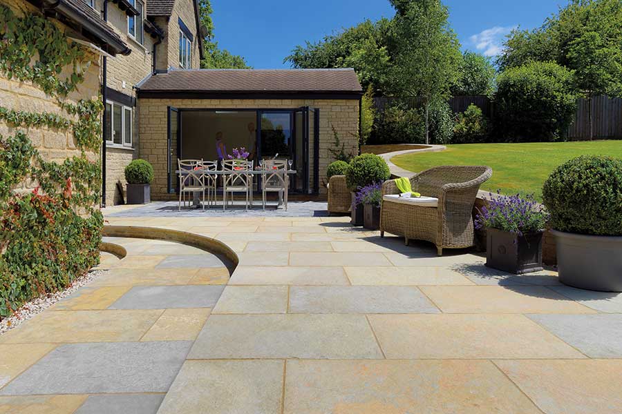Lovely large patio paved with Pavestone Abbey limestone paving laid in a random pattern