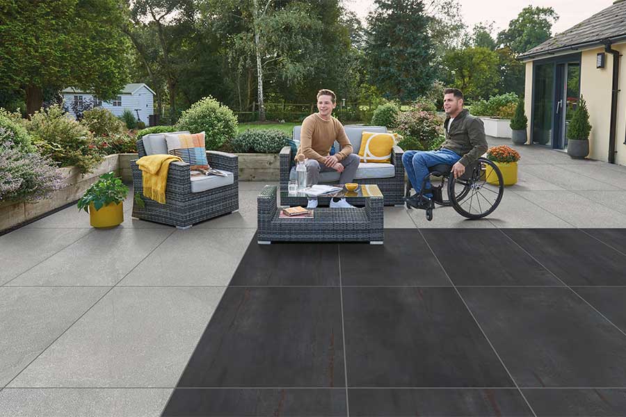 Large modern patio paved with Bradstone Metallics Lead porcelain paving slabs in graphite colour
