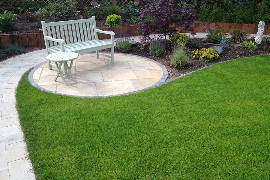 Luscious green green lawn surrounded by a natural stone patio