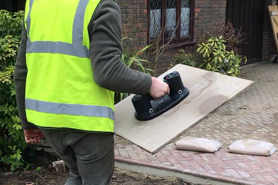 Paving contractor using Grabo electronic suction lifters to move porous natural stone paving slabs 