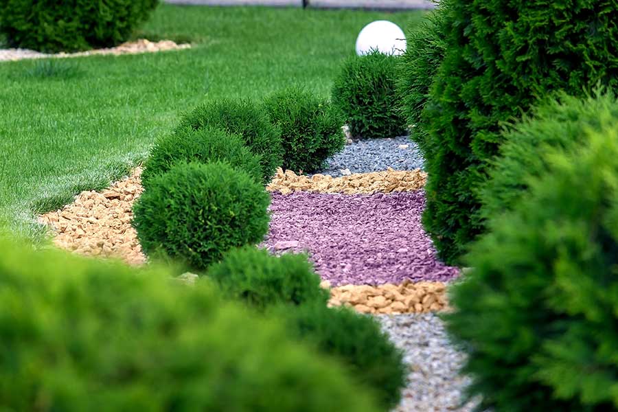 Attractive garden with colourful decorative stone and slate chippings used to mulch flower beds