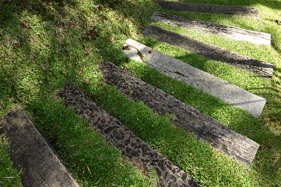 Garden sleepers used as an alternative to paving for stepping stones in a lawn