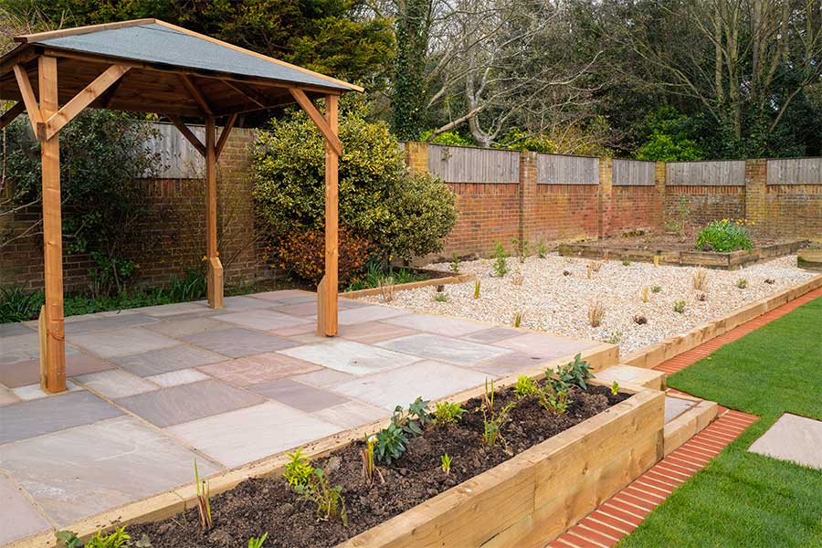 A modern raised patio edges with softwood railway sleepers