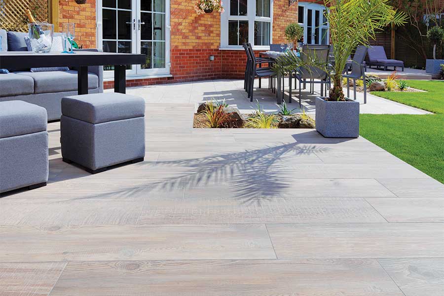 Wood effect porcelain paving slabs used for a large sunny patio