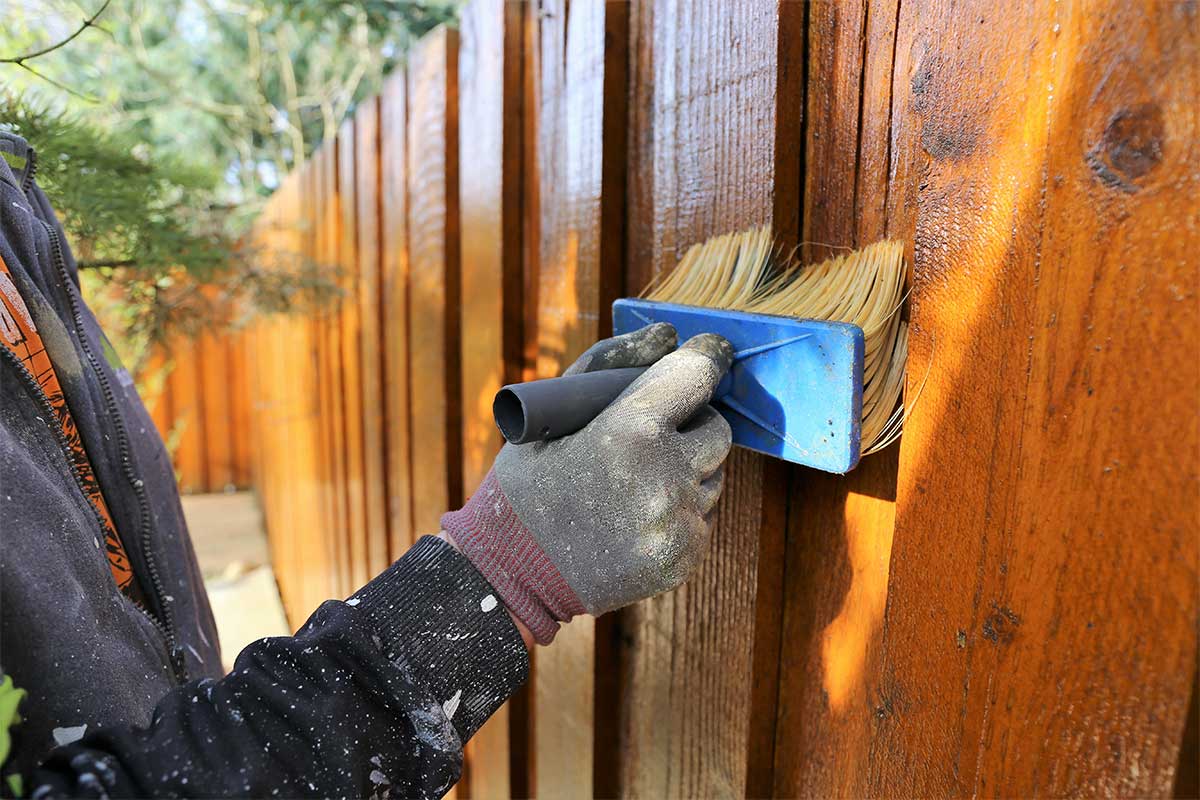 Staining a fence to protect it from wet winter weather and storms