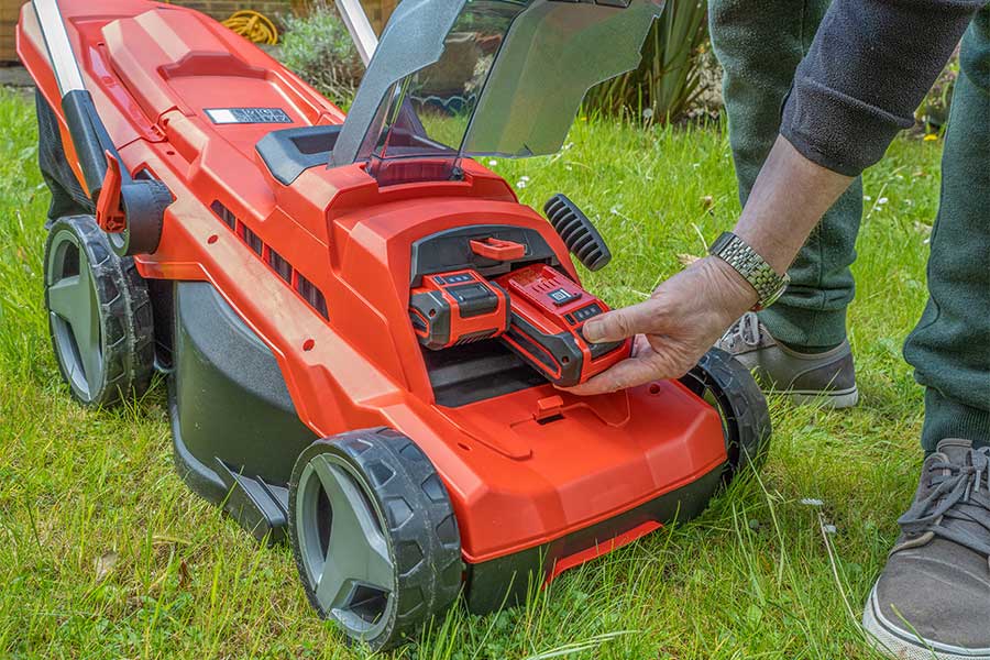 Removing the batteries from a cordless lawn mower before winter storage